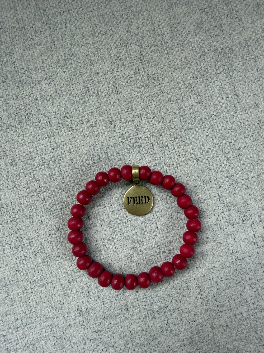 FEED Red Beaded Stretch Bracelet with Brass Logo Charm